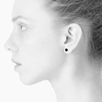 Sign earrings for him and her. Black and gold. Gold-plated sterling silver. Scherning Copenhagen